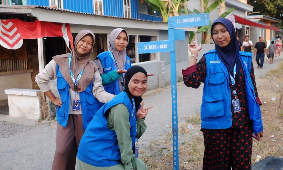 Mahasiswa KKN-Dik Unismuh di depan papan penanda lorong Pulau Balang Caddi.