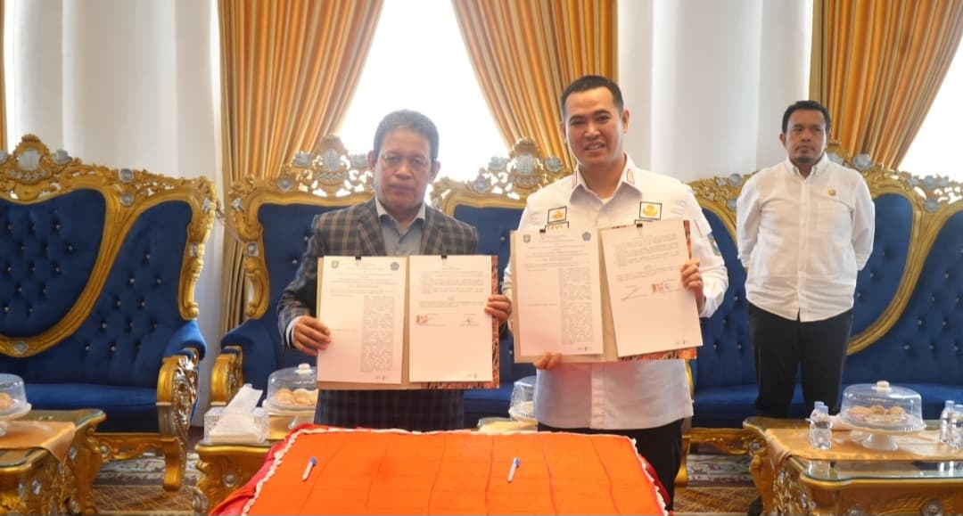 Rektor Unismuh dan Bupati Pangkep memperlihatkan dokumen kesepakatan bersama.